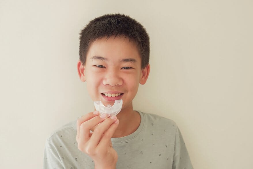 kid holding Invisalign in Aventura