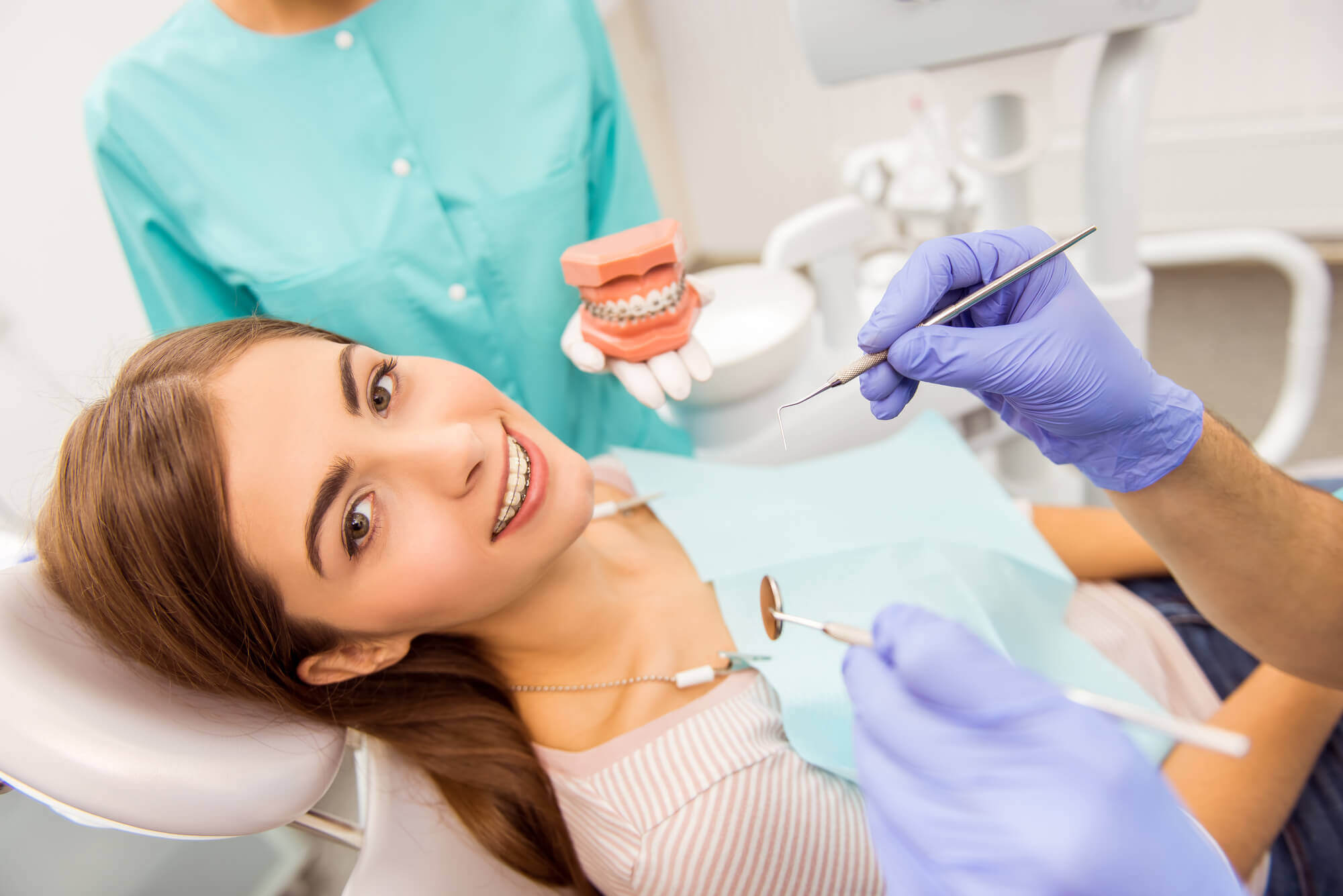 Woman smiling at a dental chair during her treatment for Orthodontics in Aventura