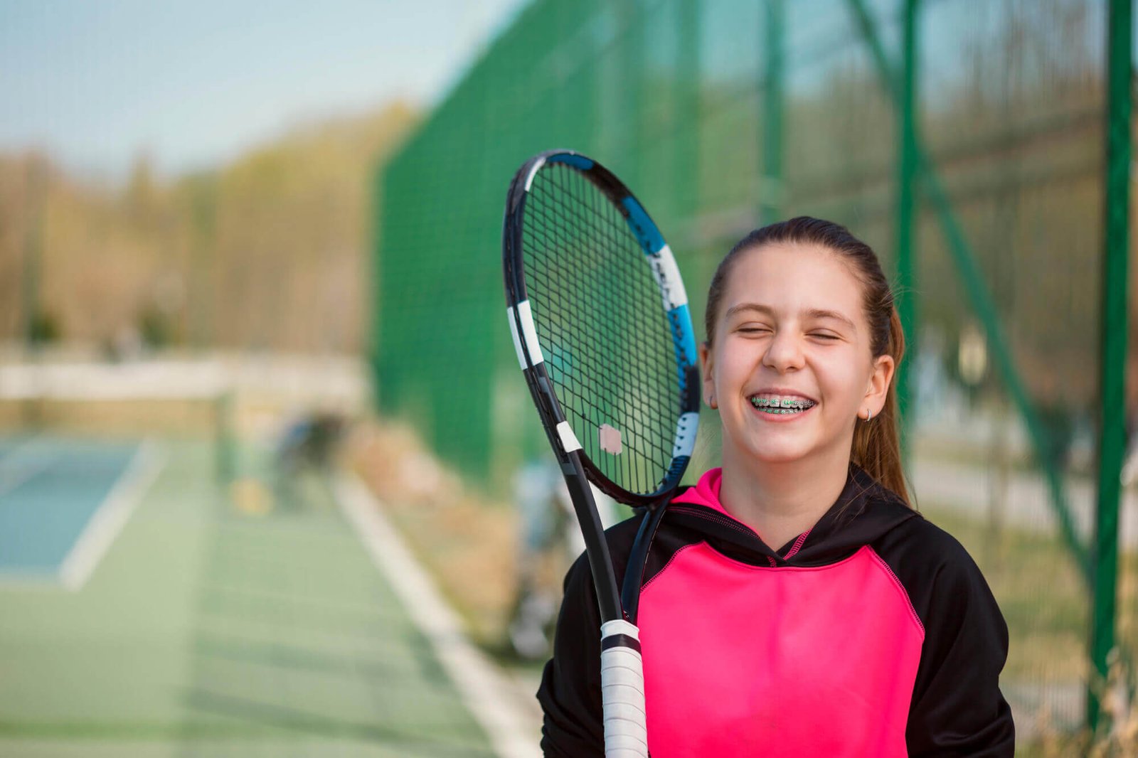 Girl playing tennis with Orthodontics Aventura