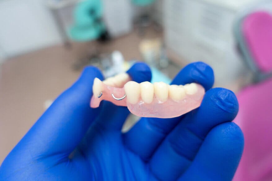 dentist holding Dentures North Miami